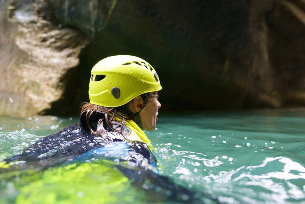 A woman swims in a canal while practicing canyoning.